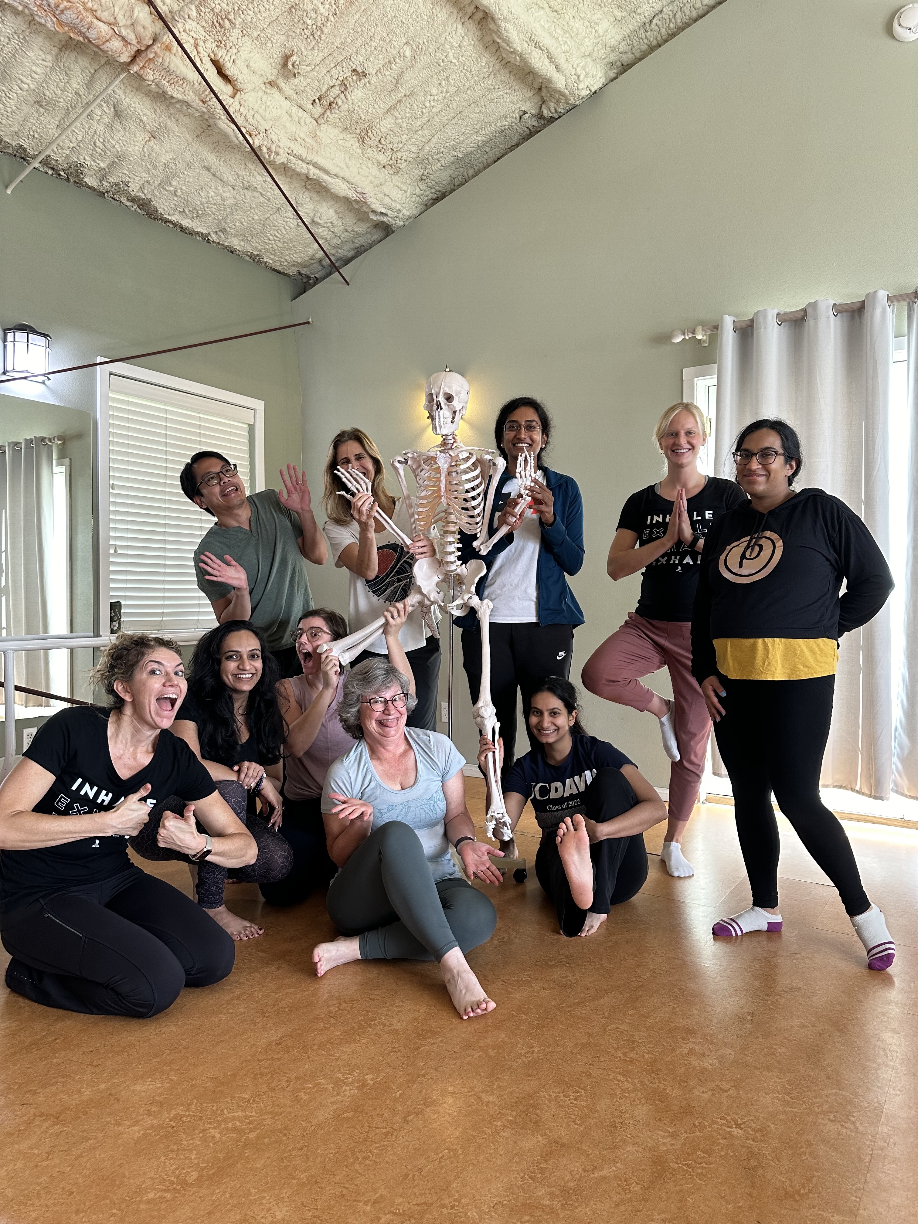 Group of teacher trainees with Michelle Spore and a skeleton anatomy model