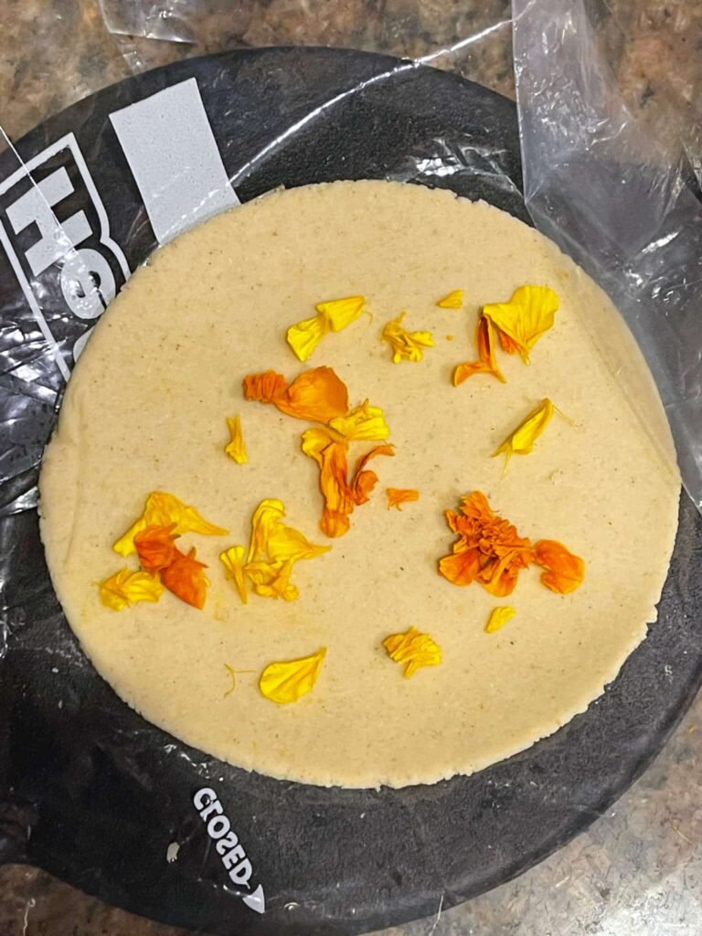 Corn tortilla with edible flowers pressed into it
